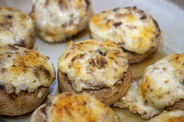 Stuffed mushrooms stuffed with cheese, mushroom stalks and onions. In a baking dish.