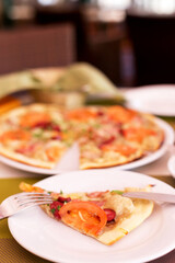 Authentic pizza with tomatoes, smoked sausage, bacon and parsley. Morning atmospheric lighting, fashionable trendy spot soft focus. Preparation for design creative menu.