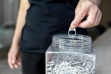 Hand holding stack of ring pull aluminum of cap cans.Raw materials for prosthetics and prosthetics...