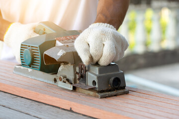 Carpenter man use electric planers for scrub wood