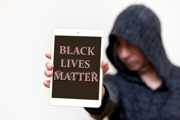 Portrait of a hooded white man holds tablet with the inscription Black Lives Matter. protests of...
