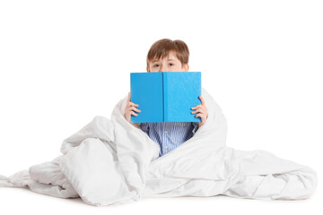 Little boy wrapped in blanket reading book on white background
