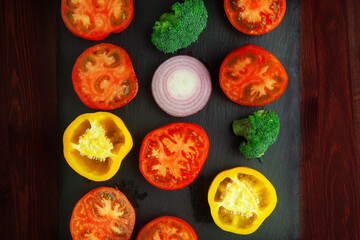 Tomatoes, peppers, brokkoli, onion on shale board