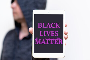 Portrait of a hooded white man holds tablet with the inscription Black Lives Matter. protests of...