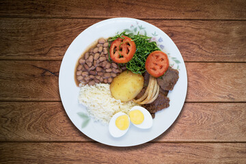 Brazilian lunch dish. Isolated on wooden background.