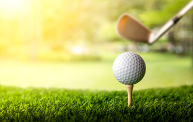 Golf club and golf ball on tee onto the green grass ready to be shot.