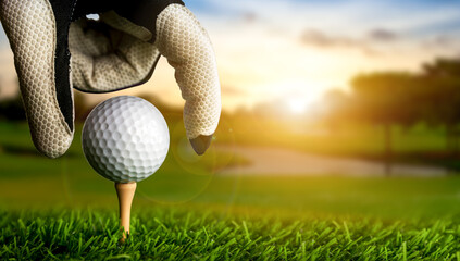 Hand of golfer putting golf ball on the tee. - obrazy, fototapety, plakaty