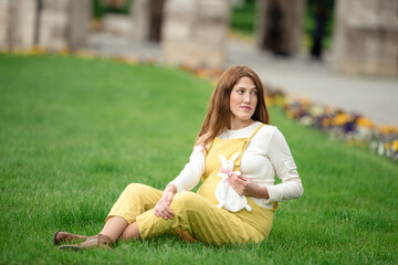 Fototapeta premium Expecting young female mother posing in park holding plush toy
