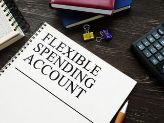 Flexible Spending Account FSA and notebooks on wooden surface.