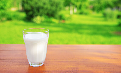 A glass of milk on the table in the garden .