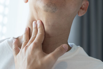 Sore throat healthcare concept. Hand of man touch his neck with red spot as sickness with pharynx...