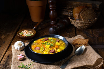 Rustic pea soup with bacon and sausages