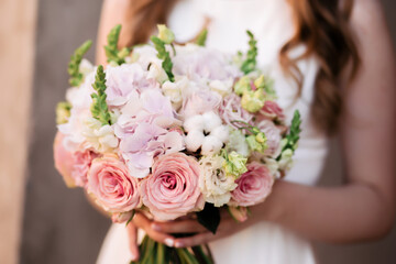 Obraz na płótnie Canvas Wedding bouquet of roses at the bride's hands