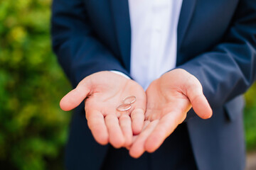 Wedding rings in the hands of the groom