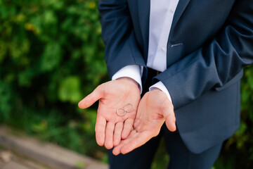 Wedding rings in the hands of the groom