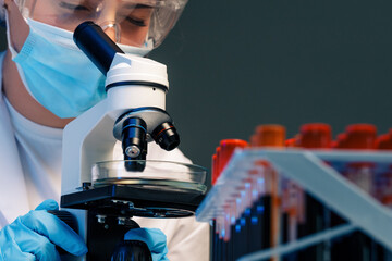 Woman scientist looking through a microscope in laboratory