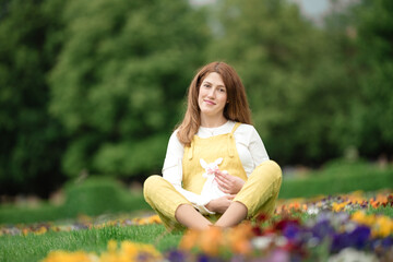 Expecting young female mother posing in park holding plush toy