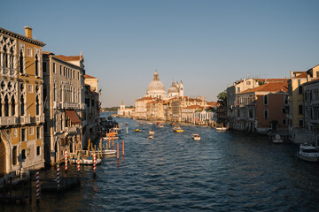 Boats are driving on the Grand Canal at sunset in Venice, Italy.