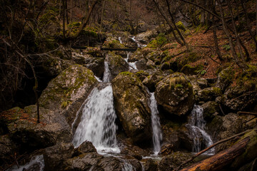 Fast flowing water over small rapids and waterfalls in Vintgar gorge, close to Borovnica, slovenia, on a dull winter day.