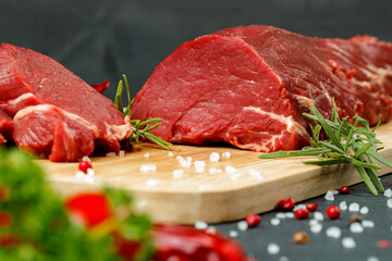 Slice of raw beef fillet on wooden board
