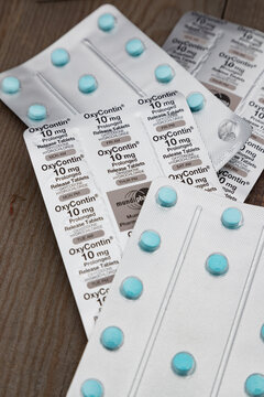 Cork, Ireland - 24th March 2019: Close up on blister packs of OxyContin pills on a wooden table, OxyContin is prescribed for severe pain but is known for being highly addictive and severely abused