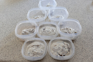  Homemade cookies and cream yogurt put into individual containers on a domestic kitchen counter.