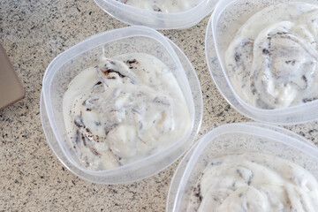  Homemade cookies and cream yogurt put into individual containers on a domestic kitchen counter.