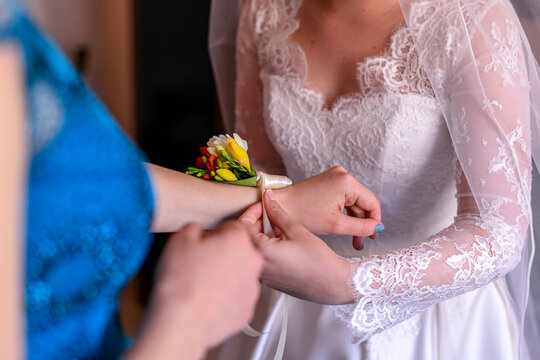 Bride putting flower on bridesmaid's hand
