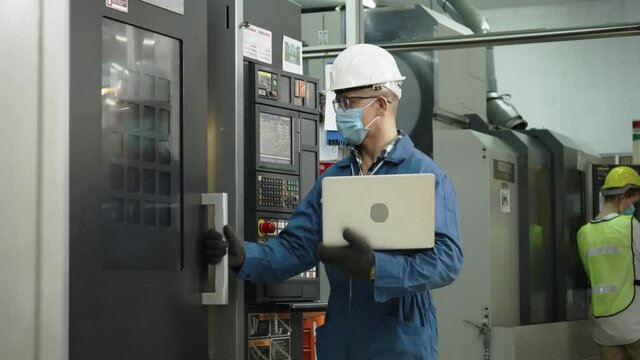 Factory engineer check machine equipment. Wear protective equipment. Safety hard hat to prevent accidents. Mask to prevent dust, Coronavirus in operation Or industrial construction. Concept New Normal