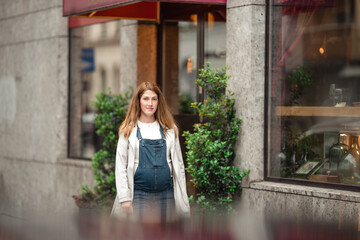Beautiful mother-to-be walking city street, childbirth preparation.