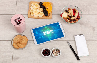 HEALTH concept in tablet with fruits, top view