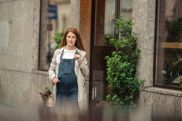 Beautiful mother-to-be walking city street, childbirth preparation.