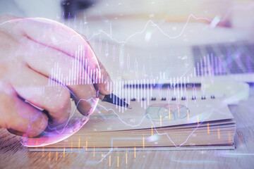Multi exposure closeup hands with stock market forex graph.