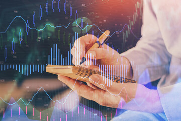 Double exposure hands with stock market chart.