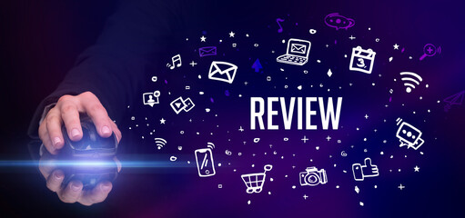 hand holding wireless peripheral with REVIEW inscription, social media concept