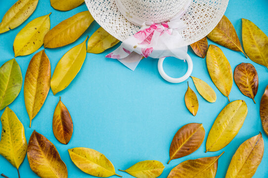 composition of yellow leaves. yellow Magnolia leaves with hat on a blue background. Flat lay, top view