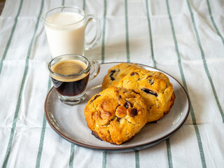 Chunky chewy chocolate chip soft cookies with cups of coffee and milk for breakfast, selective focus on cookies