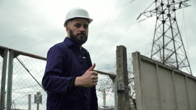 Engineer working near near power station. Energy efficiency conception. Transmission towers