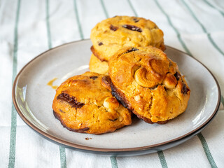 Chunky chewy chocolate chip soft cookie on dish for breakfast, selective focus on cashew nut