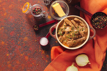 Tasty beef stroganoff in pot on color background