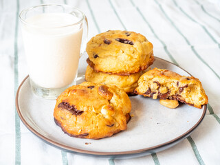 Chunky chewy chocolate chip soft cookies with cup of cold milk for breakfast, selective focus on cookie