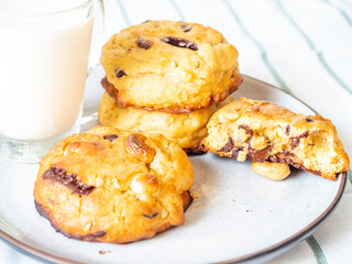 Chunky chewy chocolate chip soft cookies with cup of cold milk for breakfast, selective focus on cookie