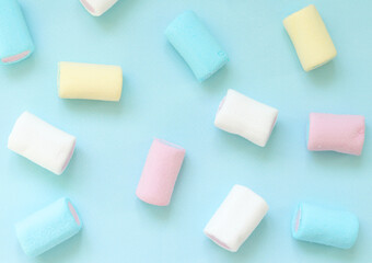 Multi-colored marshmallows in pastel colors on a gray background. Background with marshmallow sweets. Selective focus. Keyboard layout.