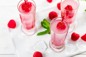 Raspberry Tequila Shots Lemonade Cocktail with Fresh Raspberry on White Background. Selective focus.