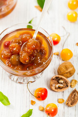 Cherry Jam with Nuts. Azerbaijani Cuisine White Cherry Preserves on Wooden Background. Selective focus.