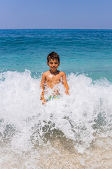 Funny kid in the middle of a giant wave