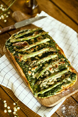 homemade pizza with asparagus and spinach on a rustic wooden table