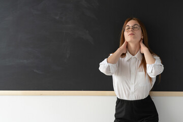 Tired university professor at the blackboard in the classroom. The board is clean and there are no inscriptions. The girl is upset and exhausted. Psychological help. Difficult life. 