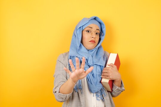 Beautiful Young Muslim Woman Wearing Hijab Over Isolated Background Afraid And Terrified With Fear, And Disgusted Expression Stop Gesture With Both Hands Saying: Stay There. Panic Concept