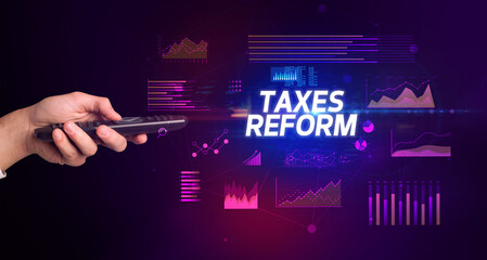 hand holding wireless peripheral with TAXES REFORM inscription, cyber business concept